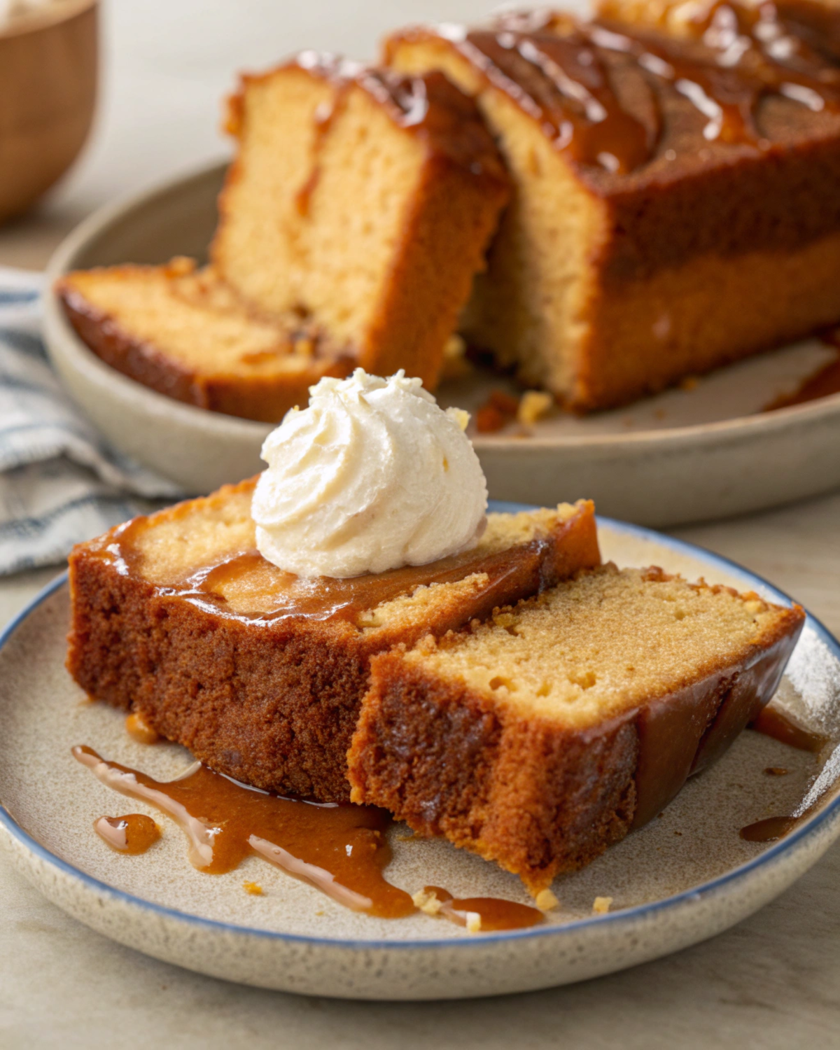 Slices of Brown Sugar Caramel Pound Cake served on a plate with a dollop of whipped cream