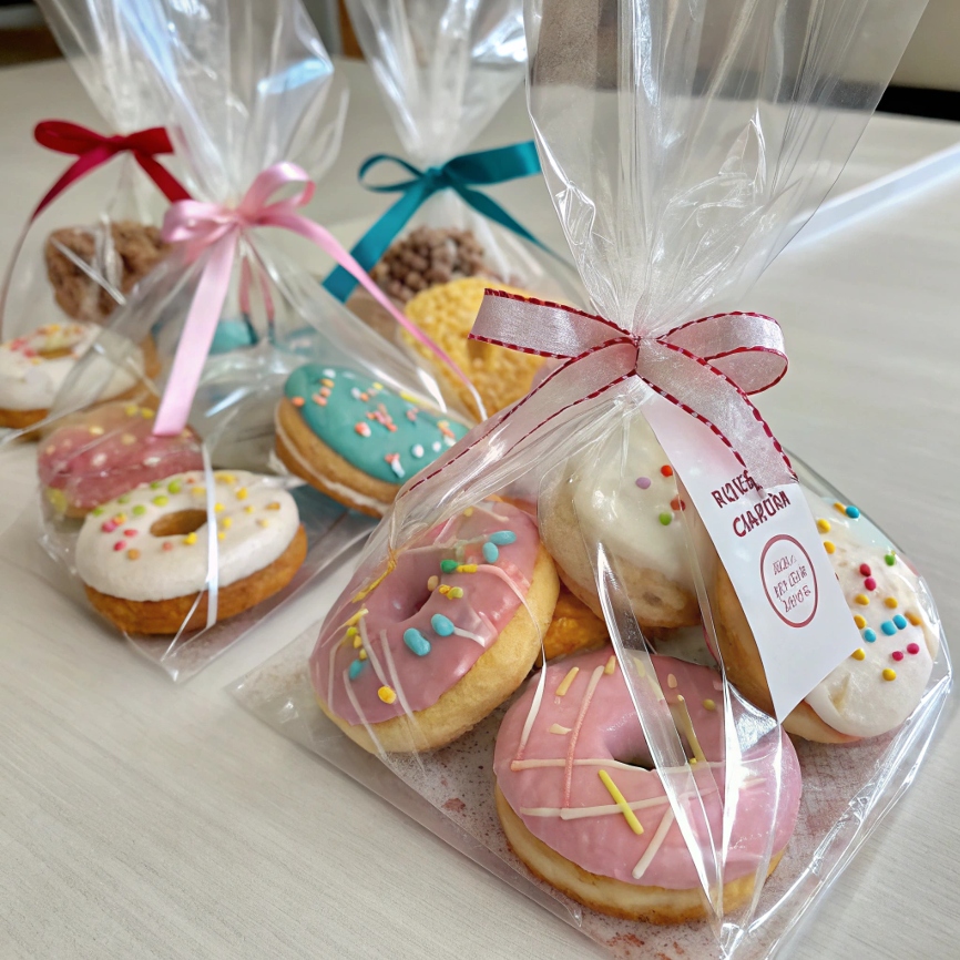 Clear plastic bags tied with ribbon, each containing homemade donuts ready for delivery or gifting.  