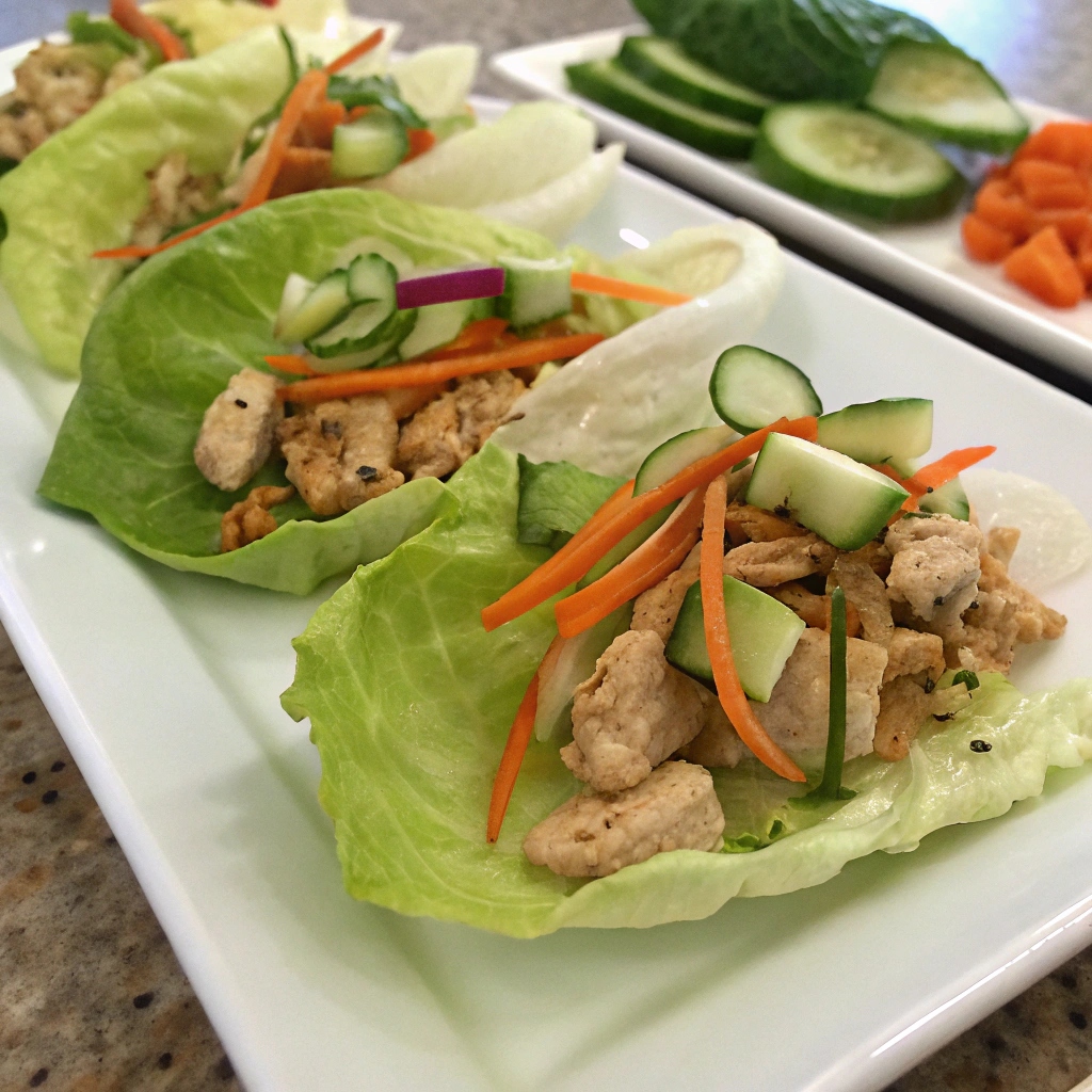 Asian Chicken Lettuce Wraps garnished with fresh vegetables
