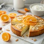 Beautifully plated Flourless Orange Ricotta Almond Cake garnished with orange zest and fresh fruit