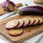 Fresh, shiny eggplants with vibrant purple skin on display at a local market.