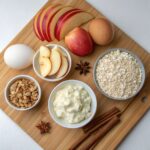 Array of ingredients for the Apple Cinnamon Cottage Cheese Oat Bake, including oats, apples, cottage cheese, eggs, and spices.