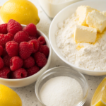 Ingredients for Raspberry Lemon Yogurt Crumble Bars including raspberries, flour, yogurt, and lemon.