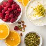 Fresh ingredients for Raspberry Orange Pistachio Ricotta Cake, including ricotta, raspberries, orange, pistachios, and more.