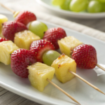 Classic fruit kabobs with strawberries, pineapple, and grapes on skewers.